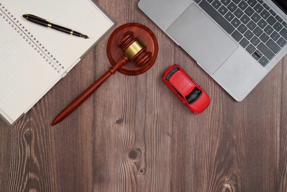 Legal tools with gavel, notebook, and toy car