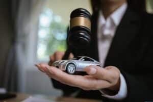Lawyer’s desk with gavel, contract, and toy car symbolizing justice, legal judgment, insurance claim, and automobile law cases.