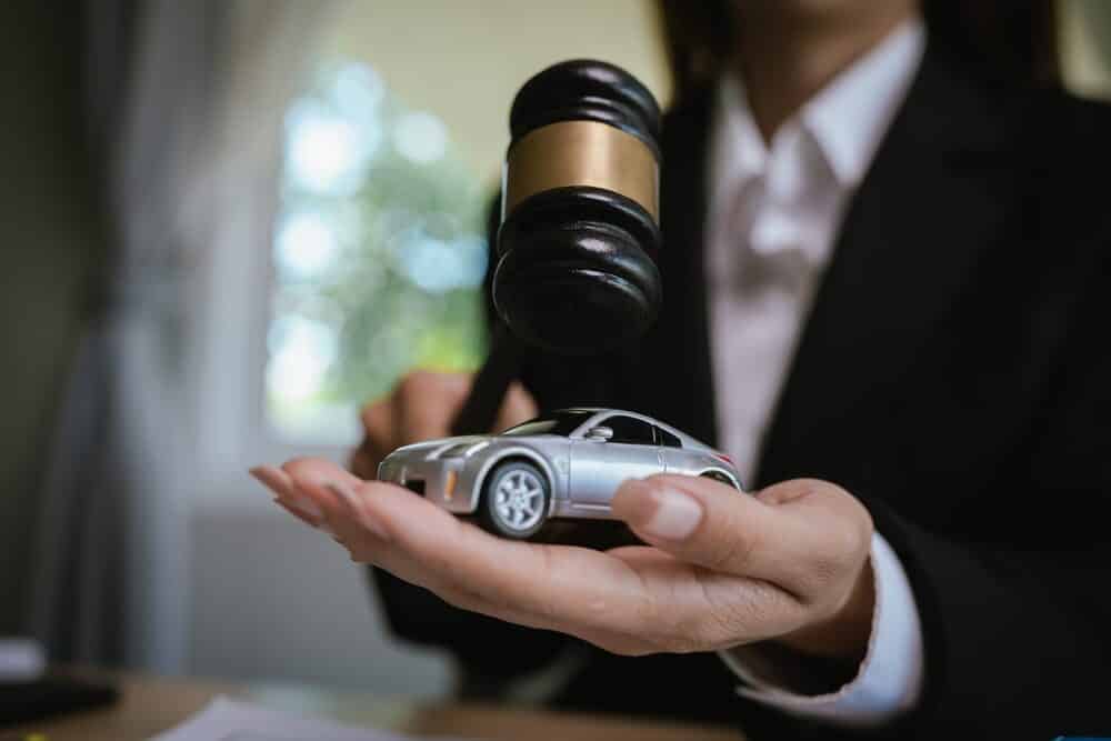 Lawyer’s desk with gavel, contract, and toy car symbolizing justice, legal judgment, insurance claim, and automobile law cases.