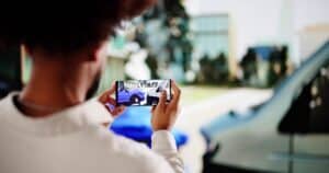 Insurance adjuster taking photos of car accident for claim process.