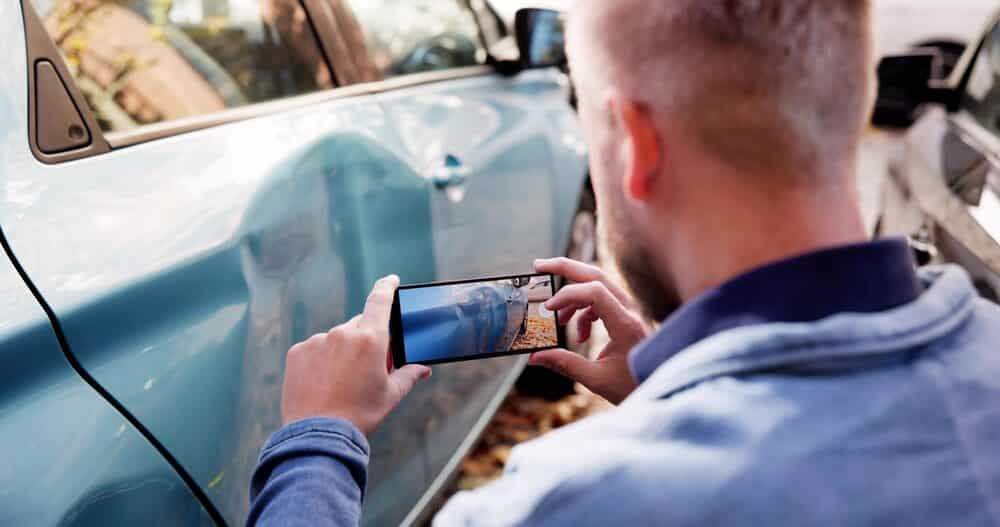 Insurance Investigator Captures Evidence Of Car Accident Aftermath On Smartphone.