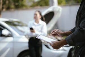 Asian woman calls insurance company for help after car accident