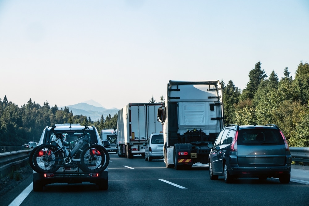 Heavy Summer Traffic on Highway with Cars, Trucks, and Bicycles