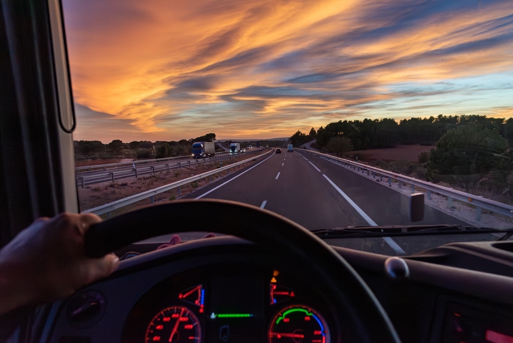 View from the driver's seat of a truck of a highway with vehicles in both directions.