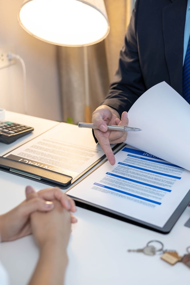 A lawyer explaining over a document what fault vs. no-fault accident laws are by state