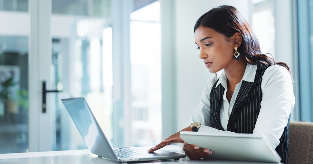 Office, serious and business woman on laptop for insurance, risk management or policy sales on internet.