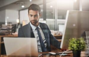 Man, business and laptop on office for finance, email and networking for growth in company. Insurance broker, computer and typing in agency for contact, feedback and online consultation with tech.