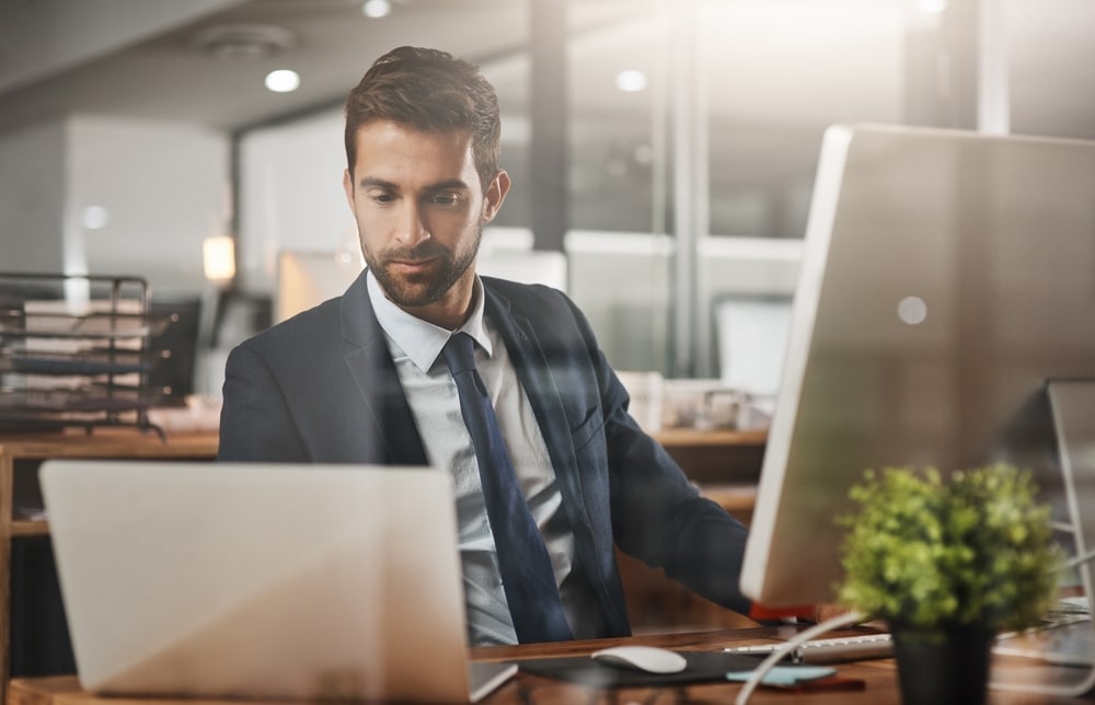 Man, business and laptop on office for finance, email and networking for growth in company. Insurance broker, computer and typing in agency for contact, feedback and online consultation with tech.