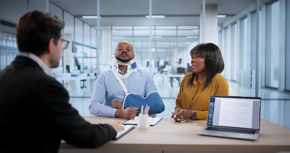 A woman and a man with a neck brace and a sling consult a lawyer. Find out what evidence you need for a personal injury claim.