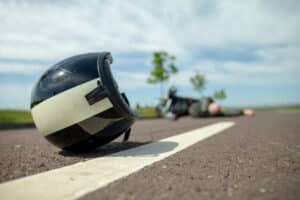 Motorcycle helmet lying on the road after a crash, illustrating what not to do after a motorcycle accident