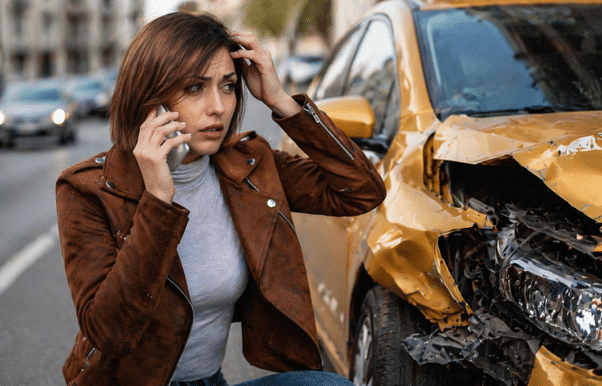 Driver calling 911 as the first step after a car accident in Newport Beach.