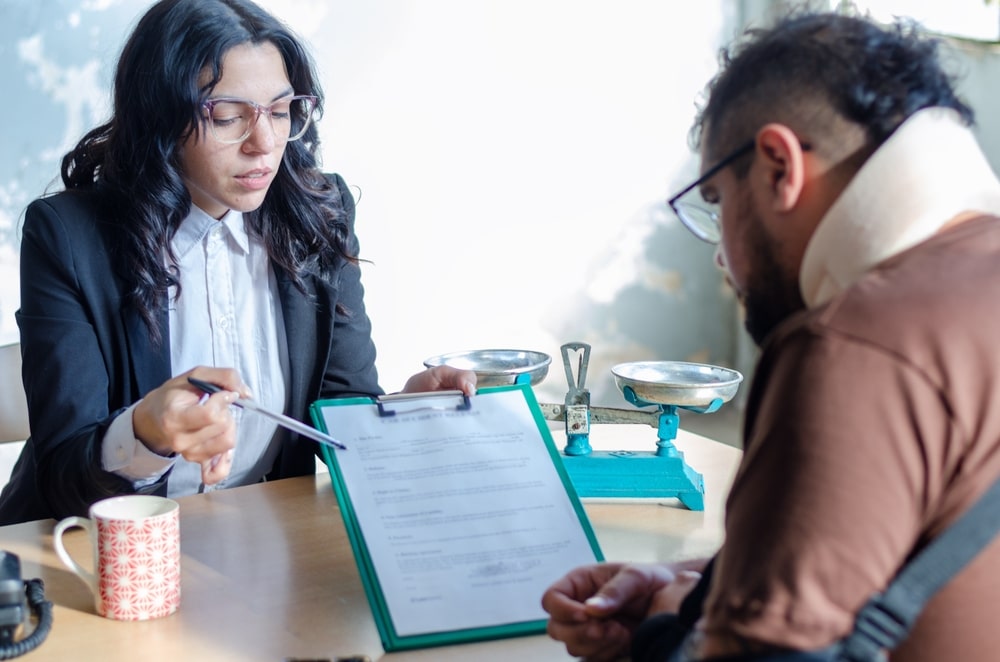 A lawyer explaining documents to a client filing a car accident claim. Learn about the car accident claim process in California.